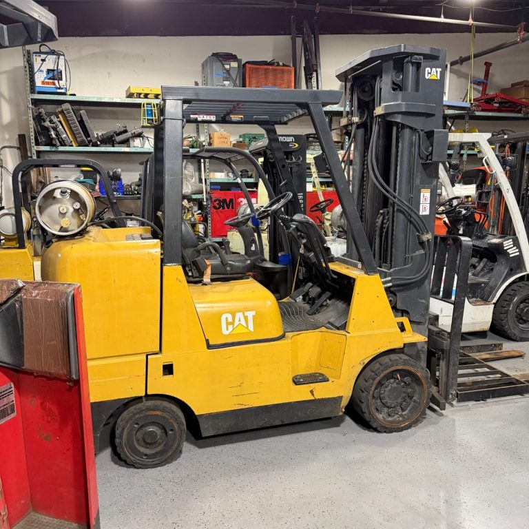 Forklift Leases Are Available Now! Yellow forklift in a cluttered warehouse with various tools in the background.